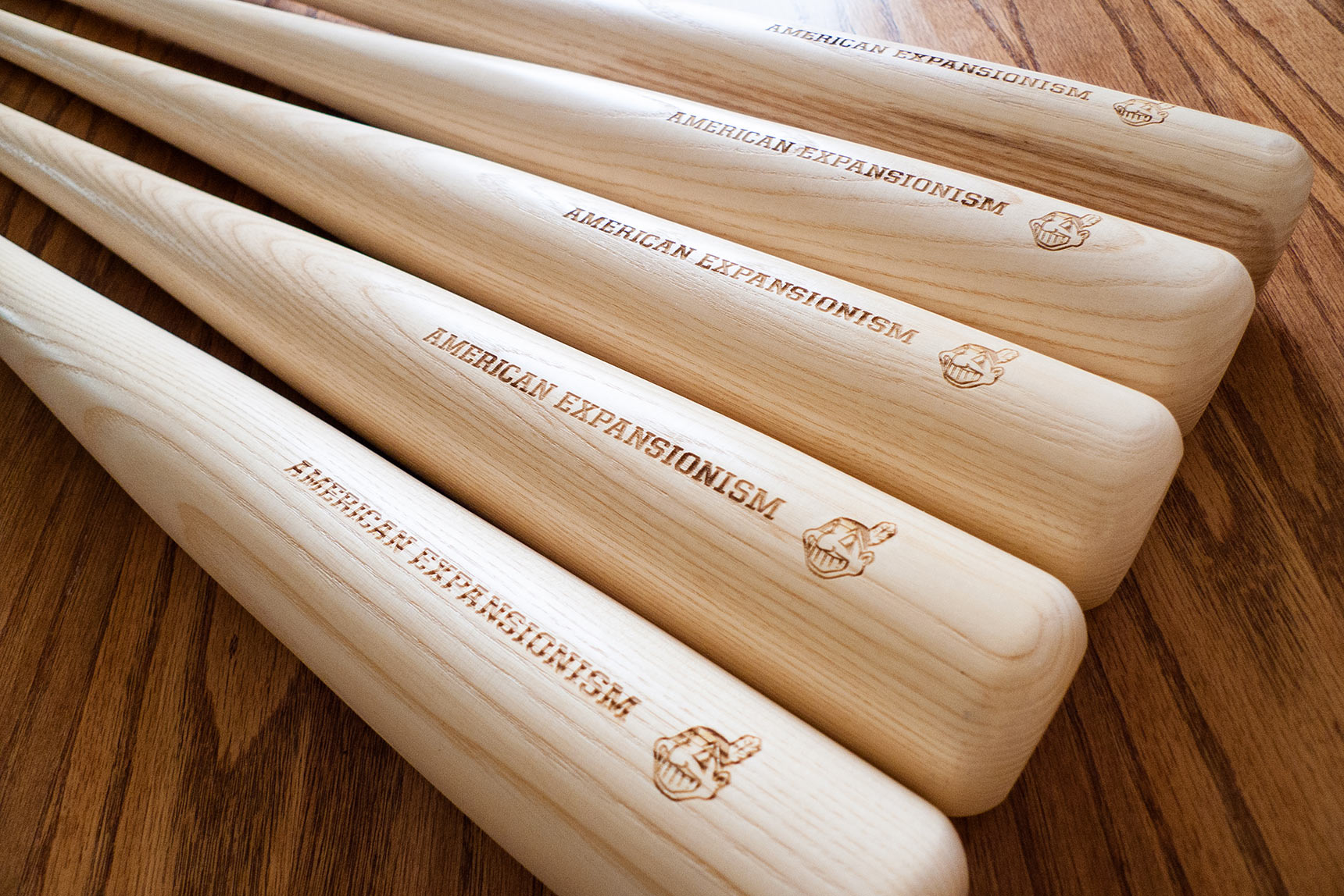 American Expansionism, 2012. A set of 5 editioned baseball bat sculpture etched with the racist caricature Cleveland Indians logo and the words American Expansionism.