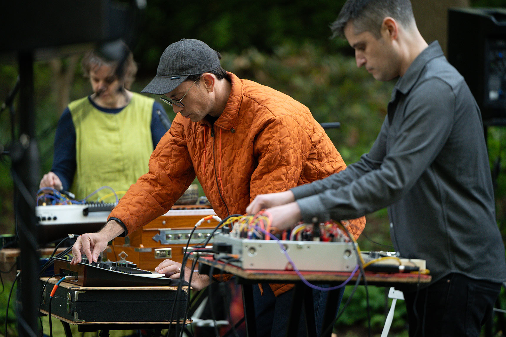 Musicians Bruce Willen, Jess Keyes, and Jason Charney each playing synthesizers, performing Music for a Ghost River in the BMA Sculpture Garden