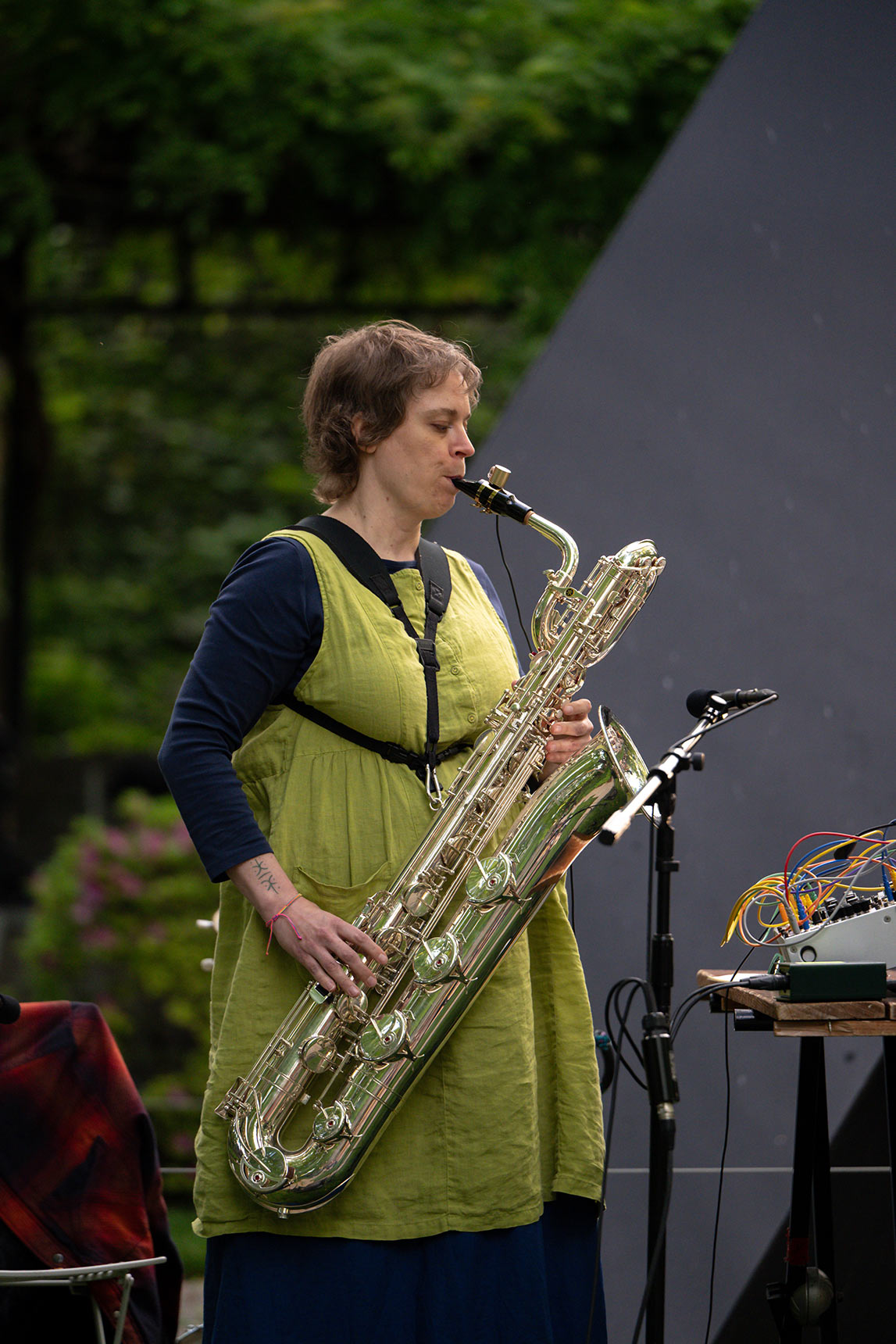 Jess Keyes playing baritone sax in the BMA Sculpture Garden