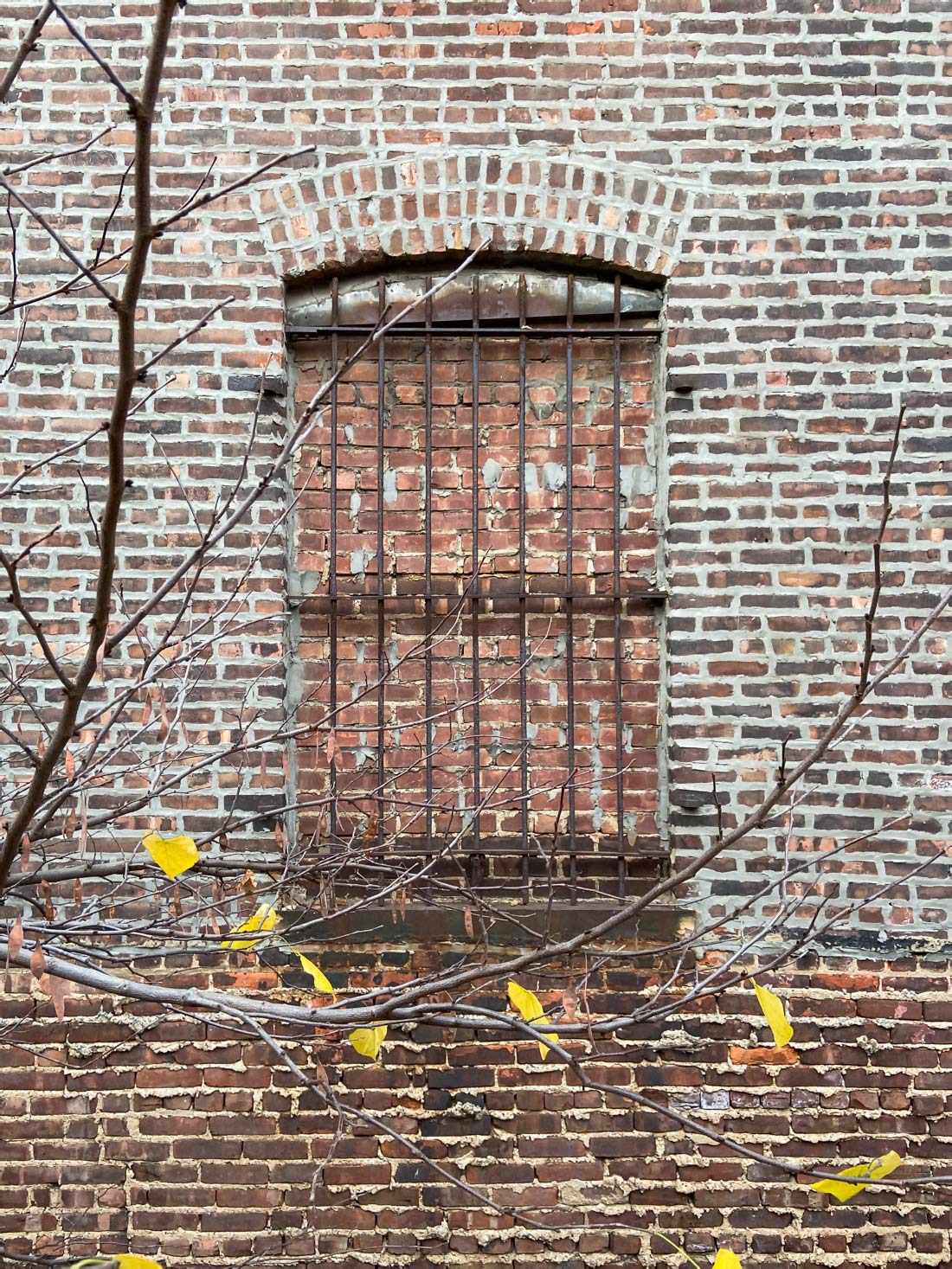 Fine art photo of a bricked up window with bars permanently sealed with bricks © Bruce Willen